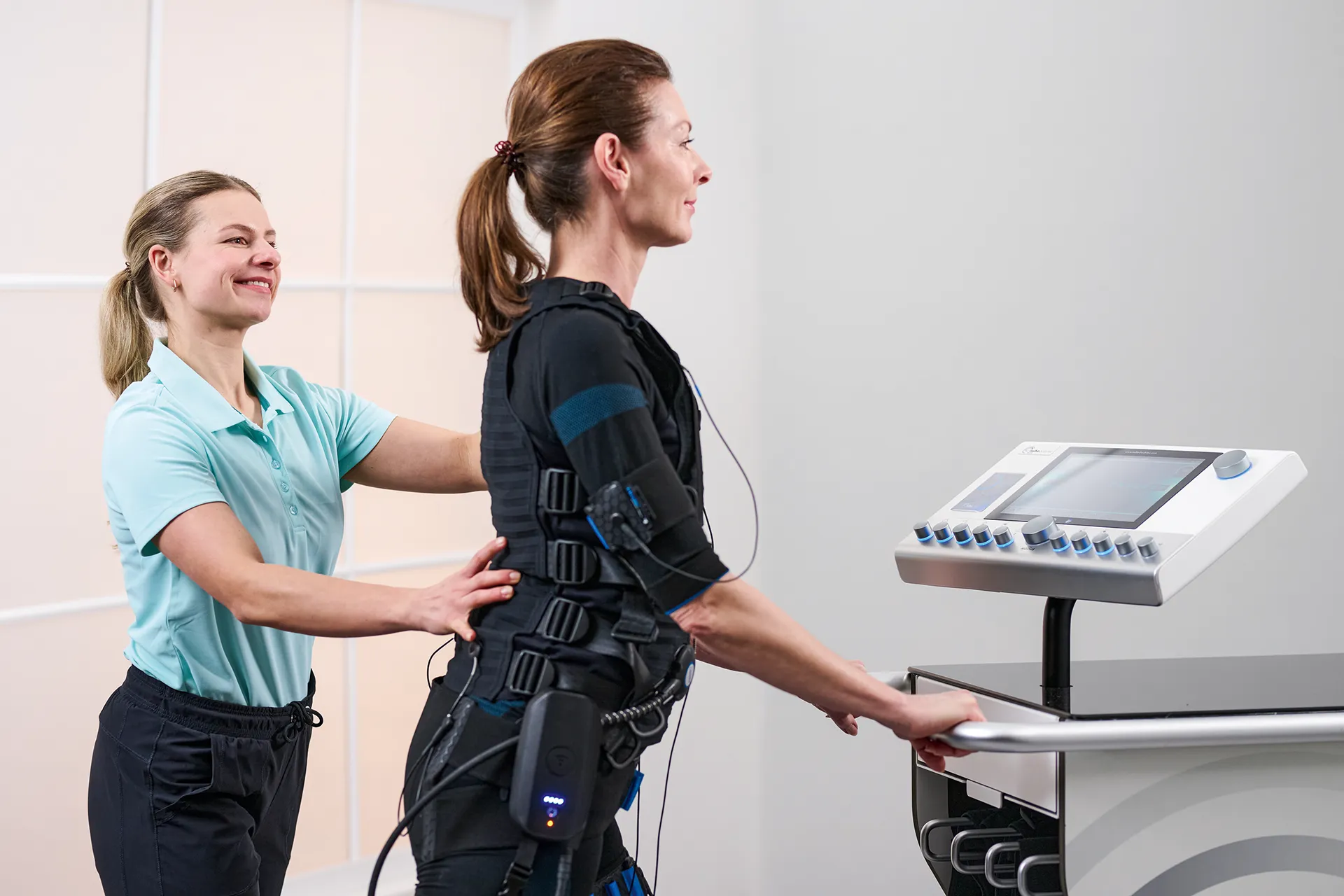 Trainerin begleitet Kundin beim EMS-Training